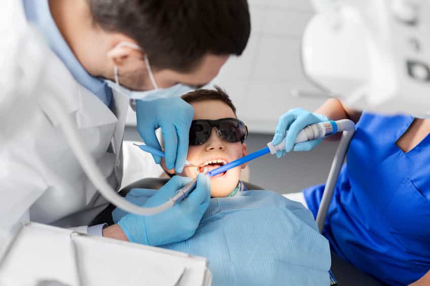 dentist treating kid teeth at dental clinic dentist treating kid teeth at dental clinic